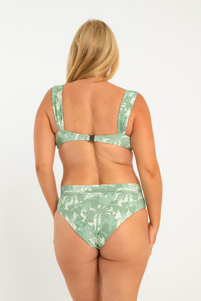 Green and white tropical printed bikini top with structured v neckline with thick straps and a metal clasp closure in the back